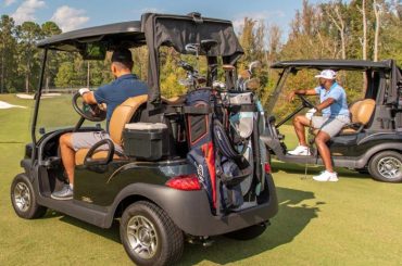Two Club Car tempos on a golf course with Club Car Connect as the players navigate the course.