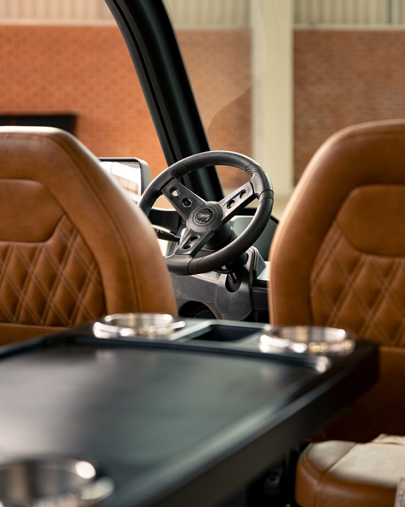 A photo of the centre table, premium seats and steering wheel of a Club Car CRU
