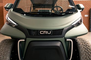A photo of the front of a Club Car CRU. The wheels and headlights are visible.