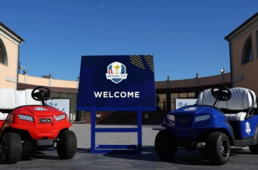 A photo of two Club Cars, one in red and the other in blue, standing at the entrance to the Ryder Cup