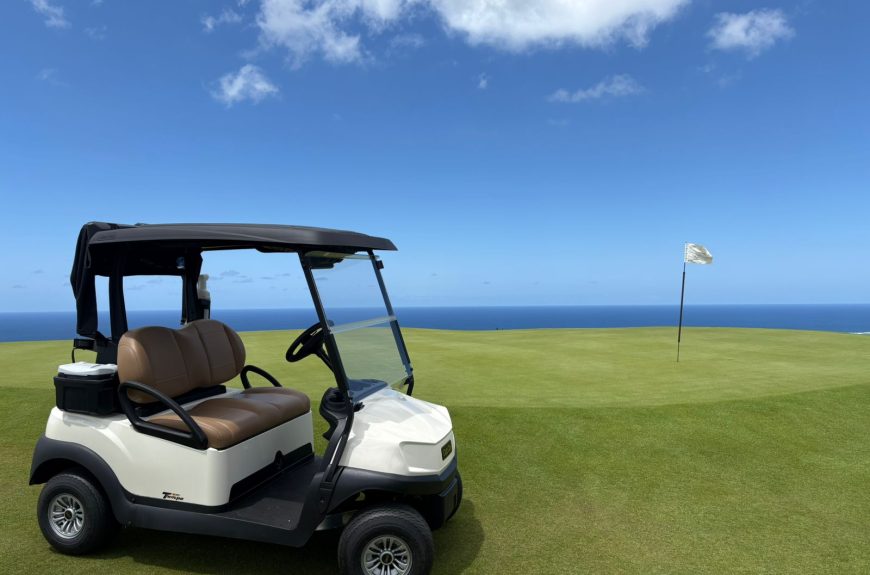 Club Car Tempo 2 Lithium golf cart parked on a fairway with ocean backdrop at La Réserve in Mauritius