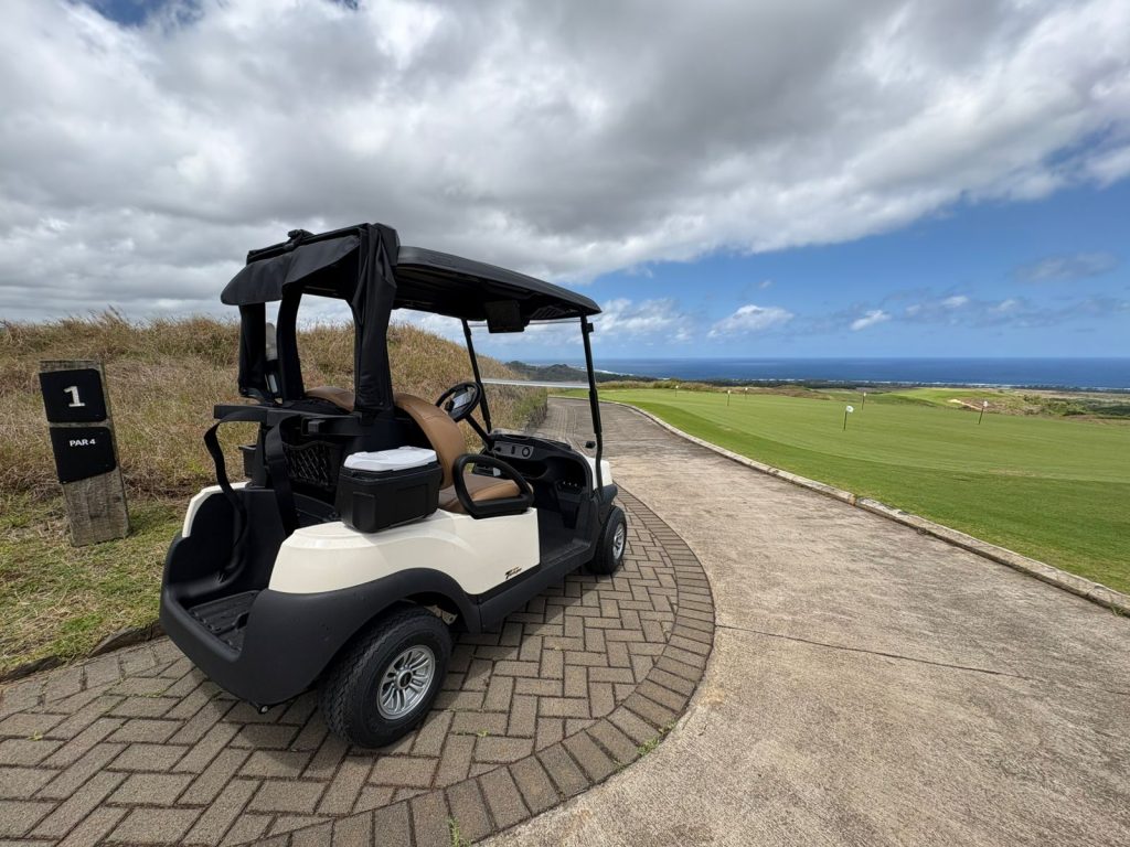 Club Car Tempo 2 Lithium cart travelling along a scenic pathway through the course at La Réserve, Mauritius
