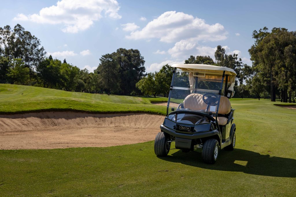 Club Car Tempo parked on a golf course on a slight slope, showcasing its smooth handling and stability across uneven terrain in a premium outdoor setting for the Club Car Difference