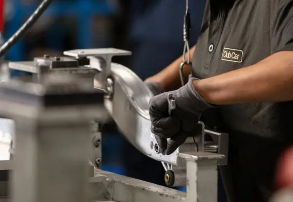 A Club Car employee working on the aluminium chassis of a Club Car for the Club Car Difference